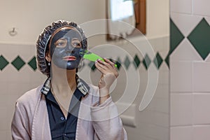 Woman doing a mud mask on her face with a scoop