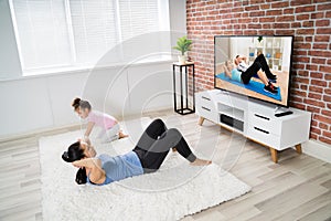 Woman Doing Online Fitness Exercise At Home