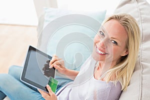 Woman doing online shopping on digital tablet in living room