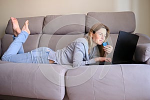 Woman doing online shopping with laptop at home