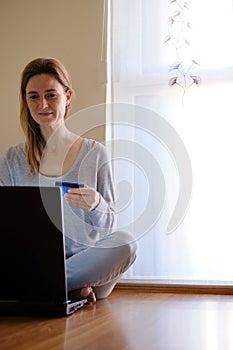 Woman doing online shopping with laptop at home