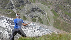 A woman is doing oriental exercises overlooking the beautiful mountains. Healthy lifestyle.