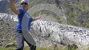 A woman is doing oriental exercises overlooking the beautiful mountains. Healthy lifestyle. slow motion