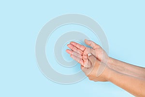 Woman doing a palm hand self masage on a light blue background