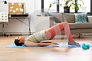 Woman doing pelvic lift abdominal exercise at home photo