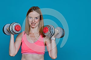 Woman doing physical exercises with very heavy dumbbells