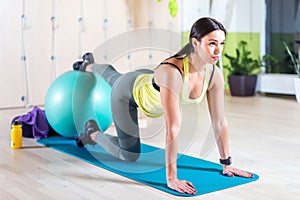 Woman doing pilates exercises with fit ball in gym