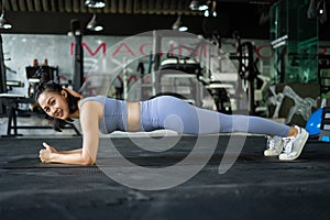 woman doing plank exercise on mat in gym. woman exercise trainer. lady sport.