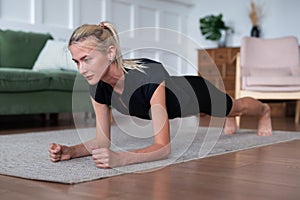 Woman doing plank exercise working out at home