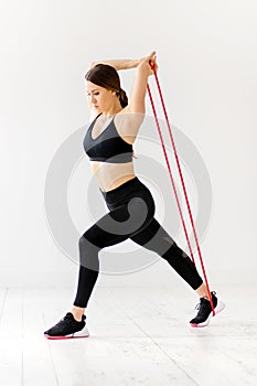 Woman doing power band fitness exercises to strengthen muscles