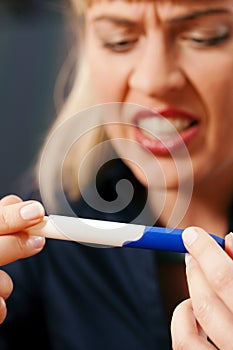 Woman doing pregnancy test being unhappy