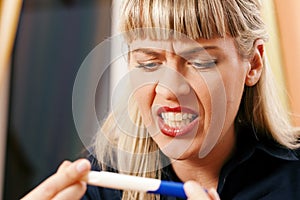 Woman doing pregnancy test being unhappy