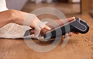 woman doing process payment invoice on the POS cash terminal in a shop, financie concept, Focus in the hand.