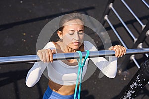 Woman doing pull-up. Strong girl in sportswear doing pull up exercise. Be H3althy.