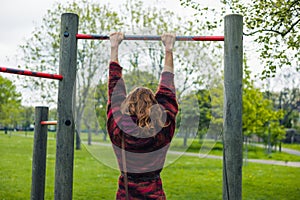 Woman doing pull ups in a park