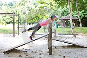 woman doing push up on bar in outdoor exercise park