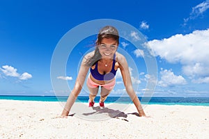 Woman doing push ups on beach