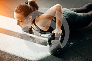 Woman doing push-ups exercises on kettlebells. Cross fit training