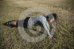 Woman doing push ups on the grass