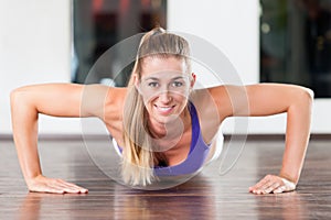 Woman doing push ups in gym