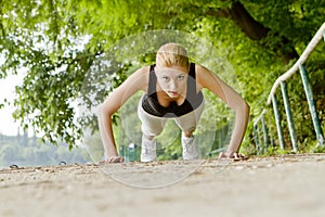 Woman doing push-ups outdoors