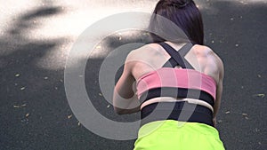 woman is doing push-ups outdoors. Fitness, street workout. Sportive woman goes in for sports