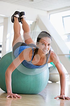 Woman Doing Push Ups On Swiss Ball At Gym