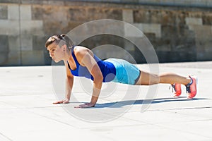 Woman doing pushups outdoor.