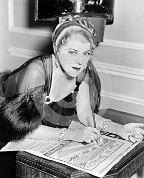 Woman doing puzzle in newspaper