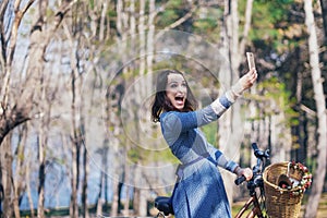Woman doing selfie in nature, beautiful girl photographed in the park on your smartphone