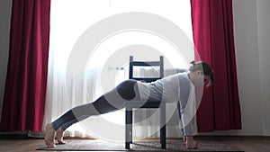 Woman doing the Shalabhasana on exercise mat at home