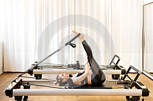 Woman doing short spine pilates exercises