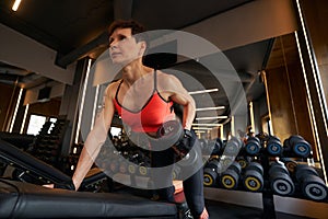 Woman doing single dumbbell workout at gym
