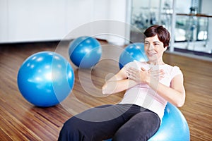 Woman doing sit ups on exercise ball. Healthy woman doing abdominal sit ups on exercise ball.
