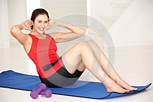 Woman doing sit-ups in home gym