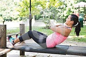 Woman doing sit ups on outdoor exercise park