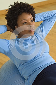 Woman Doing Sit-Ups On A Pilates Ball