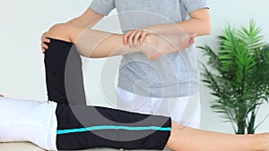 Woman doing some exercises helped by a physiotherapist