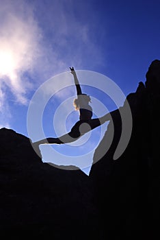 Woman doing splits on a mountaintop