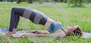 Woman doing sports exercises in the park. The sportswoman performs exercises in nature. Sports activities in nature
