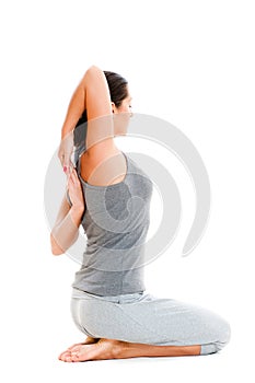 Woman doing stretch exercise in grey clothes