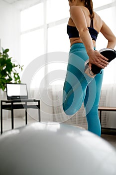 Woman doing stretching exercise, online training