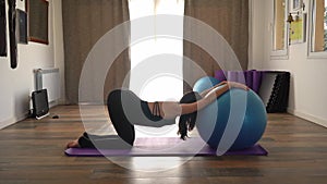 Woman doing stretching exercises at a yoga studio with a stability ball. Fitness, sports, and a healthy lifestyle
