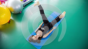 Woman doing stretching on fitness mat