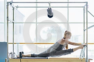 Woman doing stretching on pilates bed.
