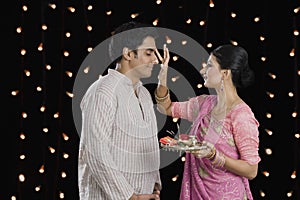 Woman doing tilak of her husband on Diwali