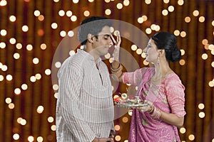 Woman doing tilak of her husband on Diwali photo