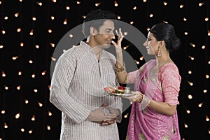 Woman doing tilak of her husband on Diwali photo