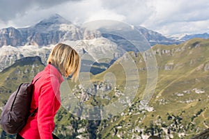 The woman doing trekking in the high mountains in the cool alps on summer days