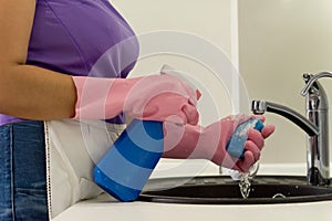 Woman doing the washing up squirting detergent